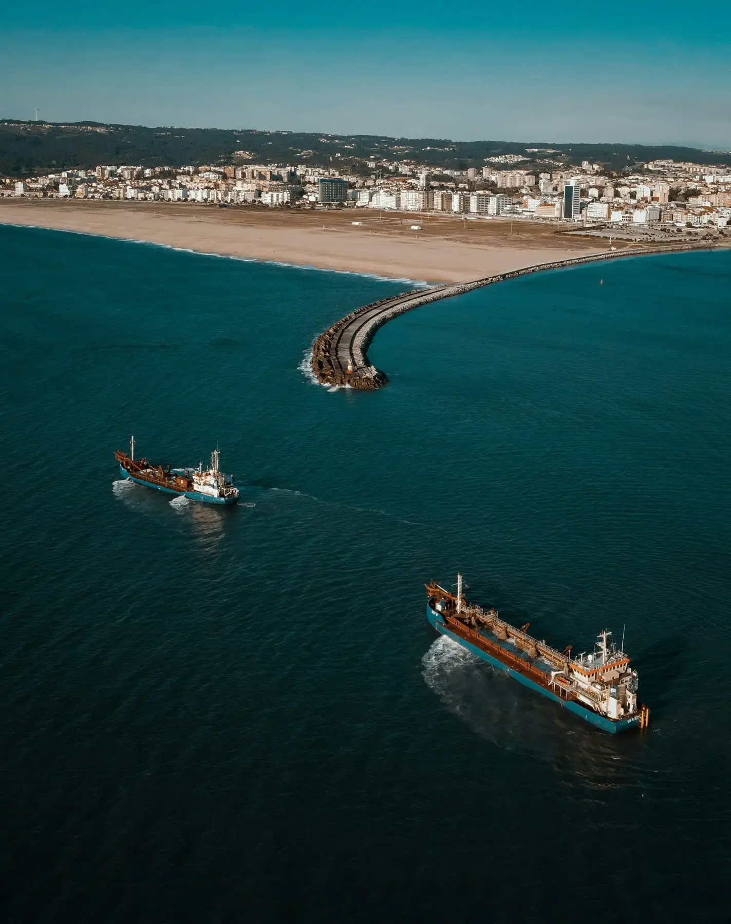 Aerial view of tankers approaching a harbour breakwater