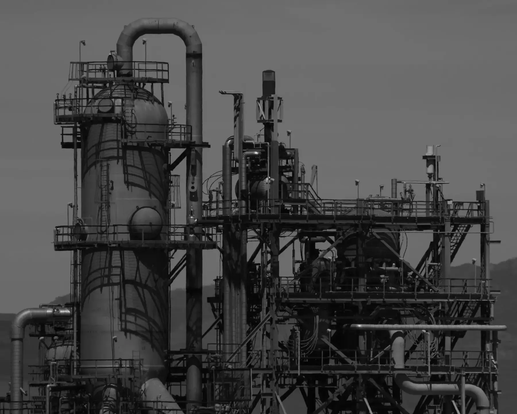 Black and white view of refinery columns and pipework
